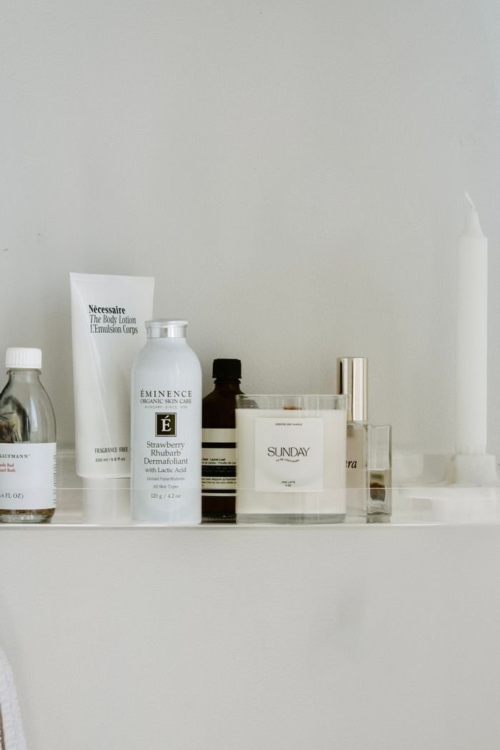 gallery-3 Stylish composition of skincare products and candle on a white shelf, ideal for wellness themes.