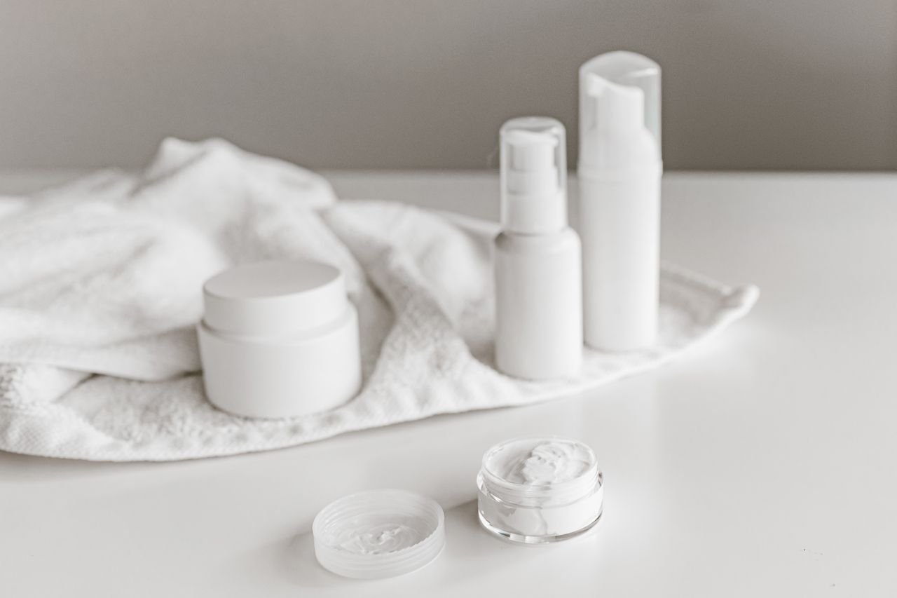Elegant display of skincare products on a white surface, highlighting simplicity and purity.